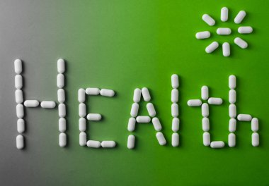 yeşil bir arka plan üzerinde kelime sağlık. Beyaz tabletler, sağlıklı bir yaşam tarzı kavramı