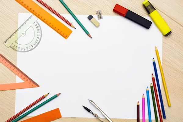 Zestaw ołówków, gumki, po jej i inne przydatne materiały szkolne. jest wyśrodkowany pusty arkusz do pisania tekstu — Zdjęcie stockowe