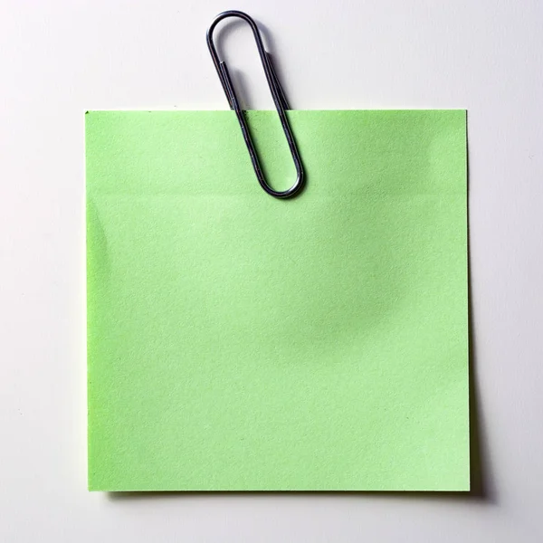 La pegatina verde con un clip de oro, aislado sobre fondo blanco — Foto de Stock