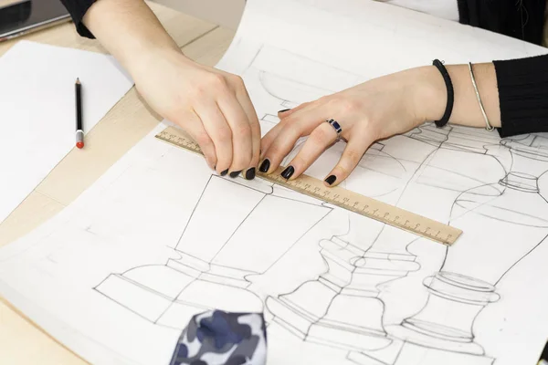 Женщина-архитектор рисует план, дизайн, геометрические формы карандашом на большом листе бумаги за рабочим столом. — стоковое фото