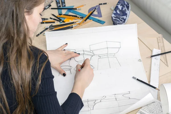 Женщина-архитектор рисует план, дизайн, геометрические формы карандашом на большом листе бумаги за рабочим столом. — стоковое фото