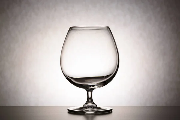 Una sola copa de brandy vacía. el concepto de vacío, de pureza, de irreflexión, de crisis de ideas —  Fotos de Stock