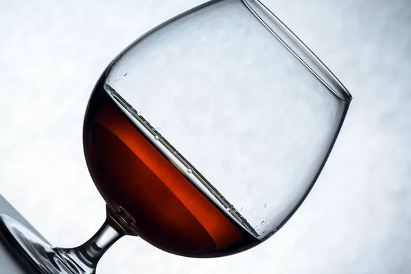 Vaso de brandy y trozos de chocolate vaso solitario de brandy, medio vacío, medio lleno. abstracción, el concepto de soledad, alcoholismo —  Fotos de Stock