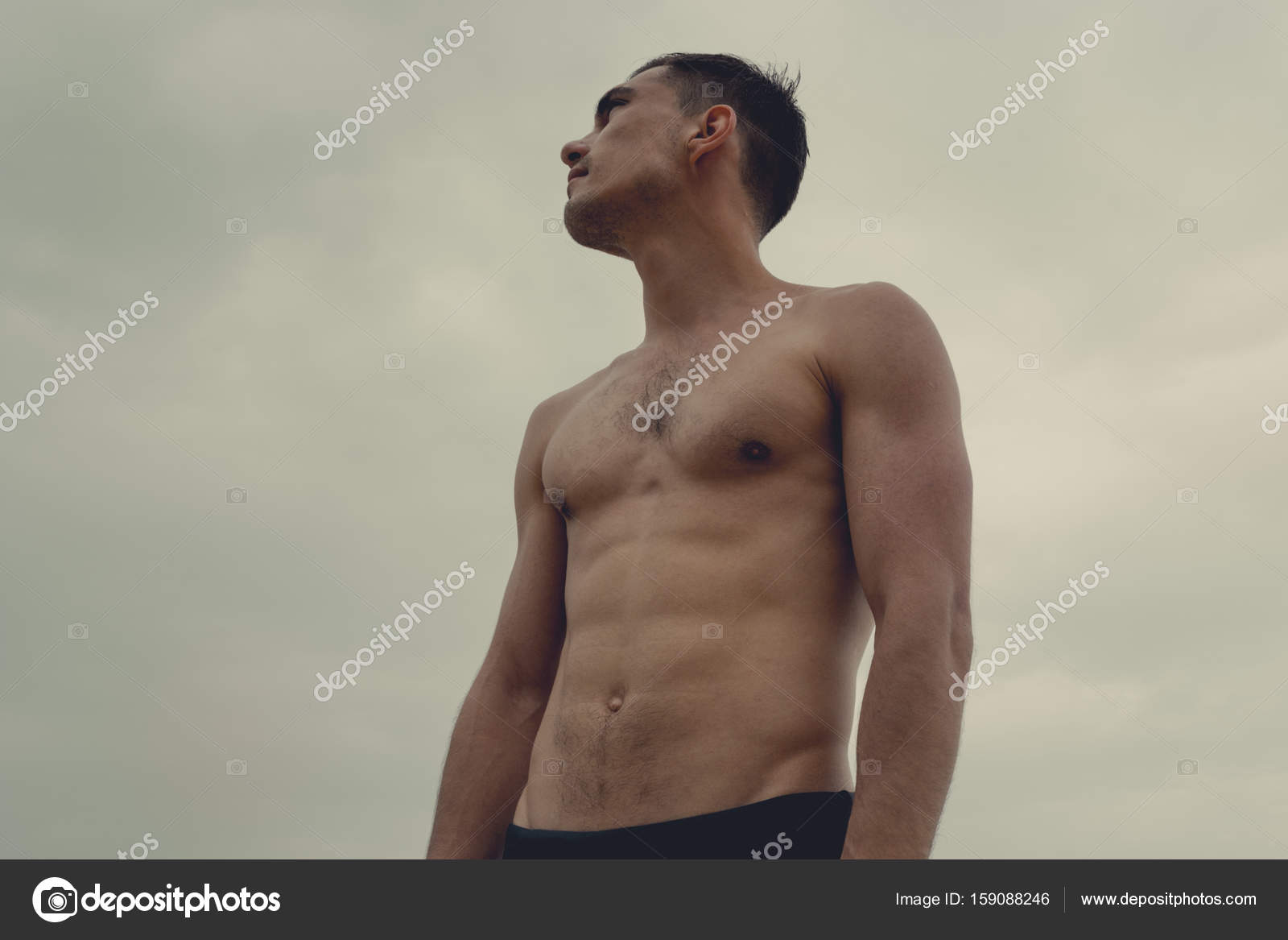 Muscular Man Standing On The Beach In A Speedo The Concept Of Freedom