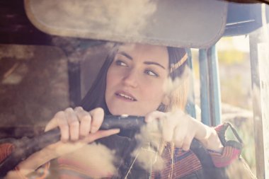 arabadaki kadın kamyon şoförü. Kameraya gülümseyen ve direksiyon tutan kız.