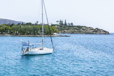Beyaz mavi denizde yelkenli yat ile güzel deniz manzarası. Sakin yelkenleri indirdi. Durgunluk, hiçbir amaç kavramı ellerini düştü.