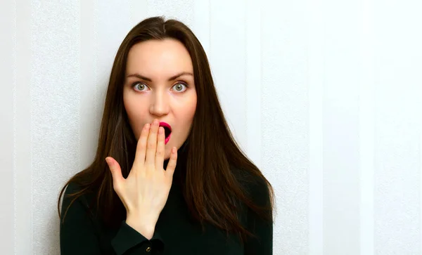 Retrato de cerca de una mujer joven, con la boca abierta, cubierta por su mano. Emociones —  Fotos de Stock