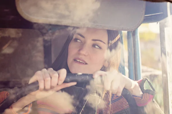 車の中で女のトラック運転手。少女カメラに笑顔とステアリング ホイールを握って. — ストック写真
