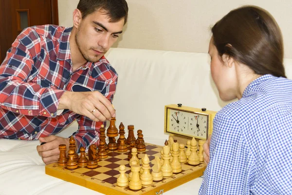 Casal jovem relaxado jogando xadrez em casa deitado no sofá. ganha - Amizade . — Fotografia de Stock