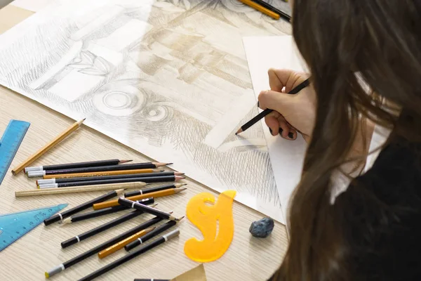 Γυναίκα αρχιτέκτονας σχεδιάζει ένα σχέδιο, σχέδιο, γεωμετρικά σχήματα με μολύβι σε μεγάλο φύλλο χαρτιού στο γραφείο. — Φωτογραφία Αρχείου
