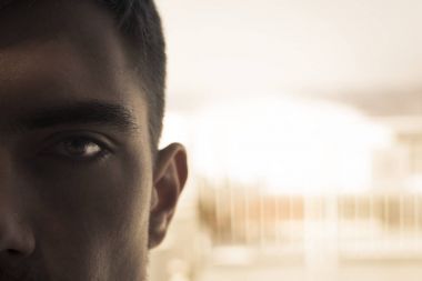 Close-Up göz gölgeler parlak bir arka plan üzerine bir genç adam. kavramı, gözetim, casusluk - sırları, ben görüyorum
