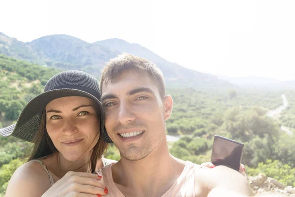 Happy resor par gör selfie bergen bakgrund, solig sommarfärger, romantisk stämning. Glad skrattande känslomässiga ansikten. — Stockfoto