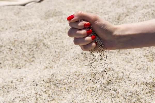 Άμμος που πέφτουν από το χέρι της γυναίκας — Φωτογραφία Αρχείου
