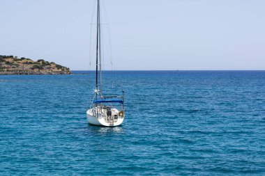 Beyaz mavi denizde yelkenli yat ile güzel deniz manzarası. Sakin yelkenleri indirdi. Durgunluk, hiçbir amaç kavramı ellerini düştü