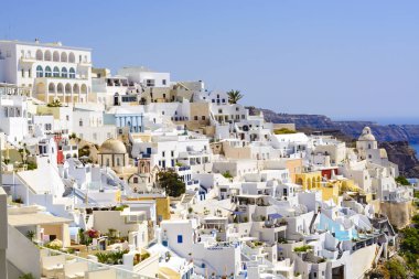 Yunanistan 'ın Santorini adasındaki Oia kasabası. Caldera, Ege denizi üzerinde mavi kubbeleri olan geleneksel ve ünlü evler ve kiliseler