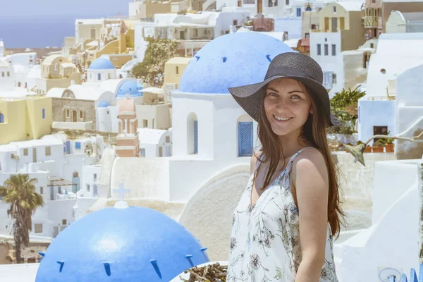 Santorini mimarisinde arka plan üzerinde beyaz elbiseli güzel bir kadın. günbatımı.