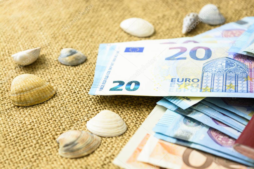 Euro banknotes, passports and shells on a linen background. the concept of travel