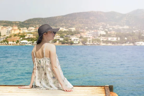 İçinde bağlantı noktası Agios Nikolaos, denizde seyir genç güzel kadın portresi açık yaz zevk onun özgürlük ve temiz hava, şık şapka ve kıyafet giyen.