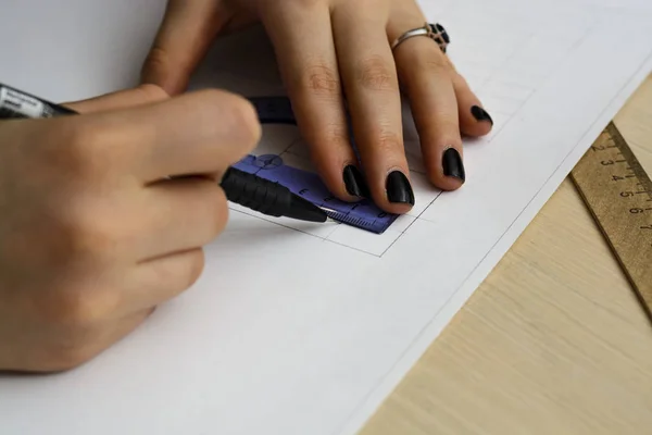 Jovem mulher - o arquiteto desenha um plano, gráfico, desenho, formas geométricas pelo lápis na grande folha de papel na mesa de escritório. imagem da cultura — Fotografia de Stock