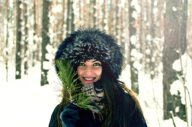Güzel genç kız kürk şapka ve Ladin şube tatlı bir gülümseme