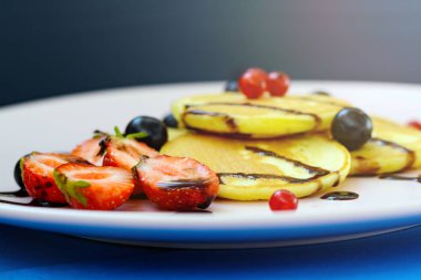 Sabah güneşin parlak ışınları meyveleri ile kırmızı krep.