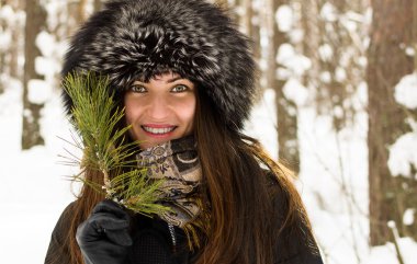 Güzel genç kız kürk şapka ve Ladin şube tatlı bir gülümseme