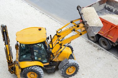 Traktör çakıl bir kamyona yükleniyor. yol çalışmaları