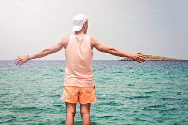 Genç adam sahilde yaz giysileri