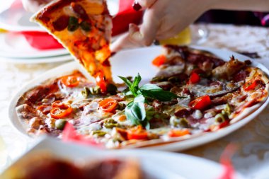 Sebze, et ve soslar üzerinde beyaz bir plaka üzerinde bir kafede lezzetli bir pizza. Yakın çekim.