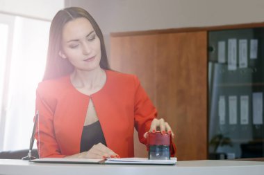 Sekreter Kırmızı elbiseli bir damga gelen iletileri koyar. ofis işleri, belge denetimi