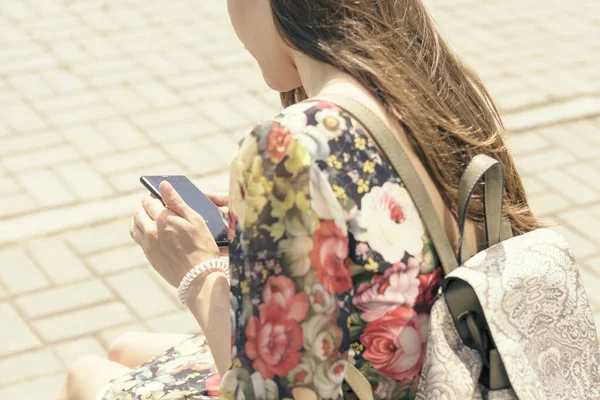 Женщина на городской скамейке со смартфоном — стоковое фото