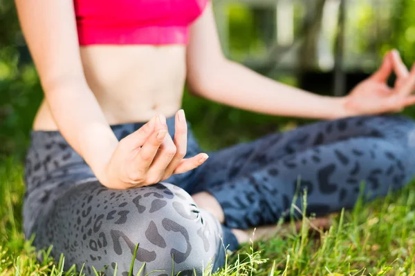 Primer plano de la mujer meditando sobre la hierba verde en el sol — Foto de Stock