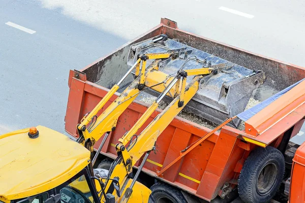 Trator carregando cascalho em um caminhão. obras rodoviárias — Fotografia de Stock