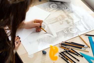 Işık ve gölge, bir desen hazırlama bir kalem ile öğrenci mimar elinde korkuluk çubuğu closeup ahşap bir masa üzerinde tasarım