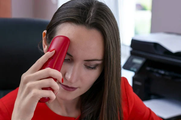 赤いスーツと赤で黒髪の魅力的なビジネスの女性の手で頭痛に苦しんで電話します。オフィスでのハードワークのコンセプトです。モノクロ. — ストック写真