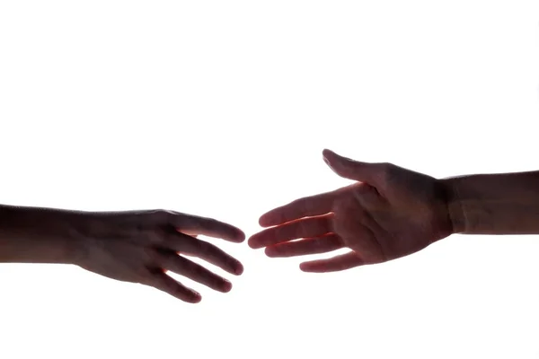 Geïsoleerde afbeelding van een silhouet van de jongen handen voor de vrouw hand te bereiken. Handen van moeder en zoon. Het concept van de familie, hulp, ondersteuning en liefde. — Stockfoto