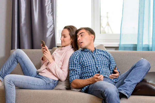 The young man in spying girlfriends phone for social networking and communication — Stock Photo, Image