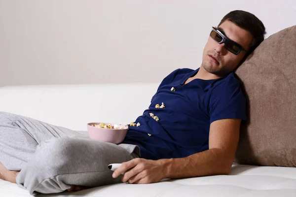 Un joven se quedó dormido mientras miraba la televisión en gafas 3D con palomitas de maíz esparcidas en la camisa — Foto de Stock