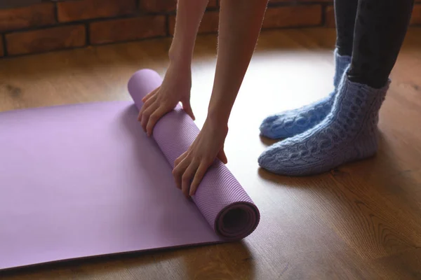 Woman in blue woolen socks turns purple Mat yoga and fitness on the parquet floor in the room — Stock Photo, Image