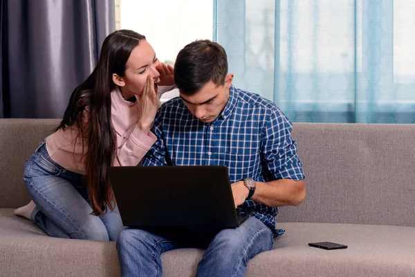 Μια νεαρή γυναίκα προσπαθεί να καλέσετε στο σύζυγό της, που κάθεται σε ένα φορητό υπολογιστή. Η έννοια της τα προβλήματα επικοινωνίας της σύγχρονης οικογένειας — Φωτογραφία Αρχείου