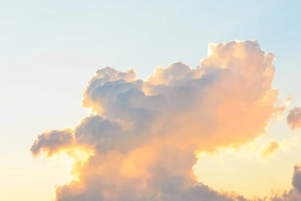 Nuages duveteux blancs dans le ciel bleu clair dans un coucher de soleil orange vif — Photo