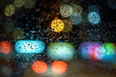 Görüntü yağmur ışıklar içinde belgili tanımlık geçmiş soyut bir Tanrı gece araba camına düşüyor. alan, kavrama, yumuşak odak sığ derinliği