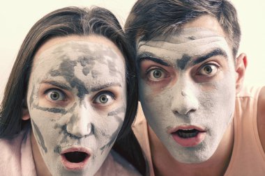 Kil maskeleri yüz için evli bir çift duygusal büyük portresi. gün Spa, sağlık, Cilt Bakımı
