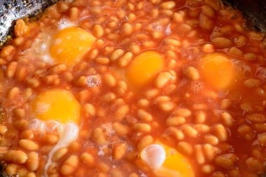 Kahvaltı bekar. soslu et suyu ile eski bir tava üzerinde fasulyeli kızarmış yumurta close-up. beslenme, yemek, tek hayat kavramı