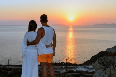 Genç bir çift günbatımında Santorini Adası'nda sarılma portresi. arka görüş. Kavram-aşk, özgürlük, ilişki, seyahat, macera