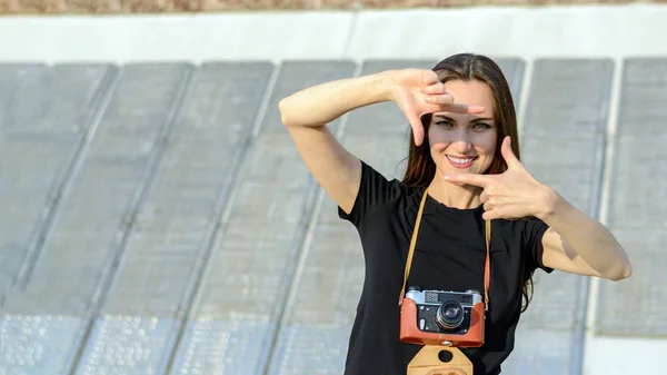 Joyeux brunette femme faisant photo avec caméra rétro sur la rue de la ville — Photo