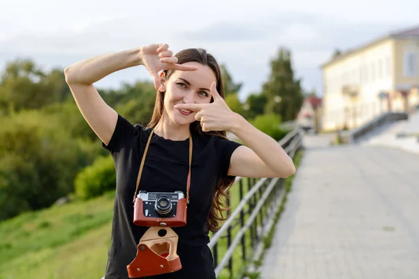 Mujer morena feliz haciendo foto con cámara retro en la calle de la ciudad — Foto de Stock