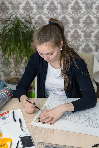 Портрет концентрированного юного студента за столом занимается рисованием архитектурного дизайна, рисунка, эскиза, геометрии, модели — стоковое фото