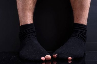 Siyah pamuklu çorap delik deşik ayaklarda. yoksulluk, iflas, yoksul, borç kavramı