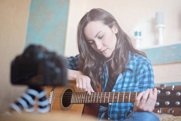 Дівчина-блогер записує на камеру DSLR підручник для відтворення акустичної гітари — стокове фото